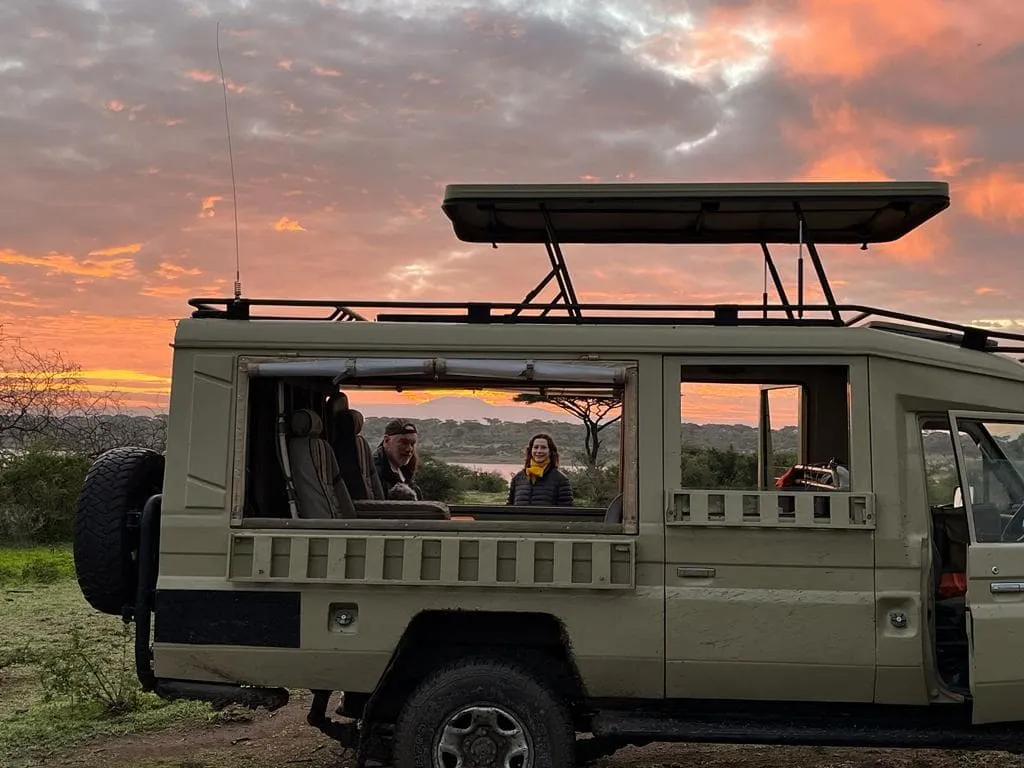Romantic safari sunset with vehicle silhouette in Tanzania